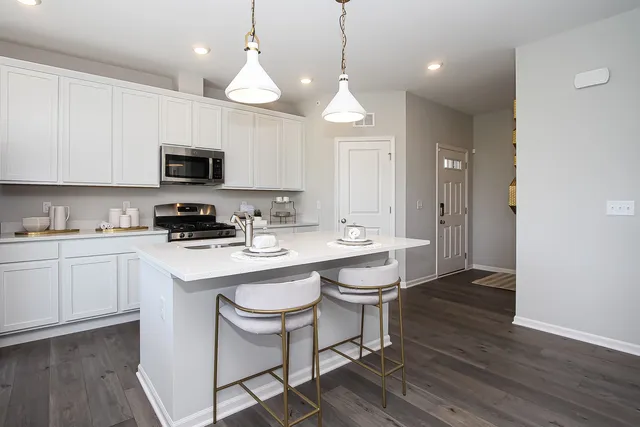 a kitchen with a sink a microwave a stove and cabinets