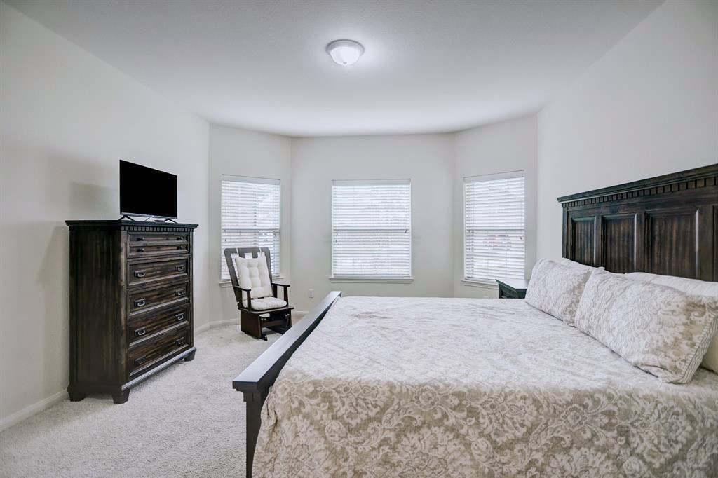 1303 Emerald Stone Drive Rosharon, TX 77583 - Photo 12 of 25 Beautifully designed primary bedroom featuring bright natural light and spacious comfort.