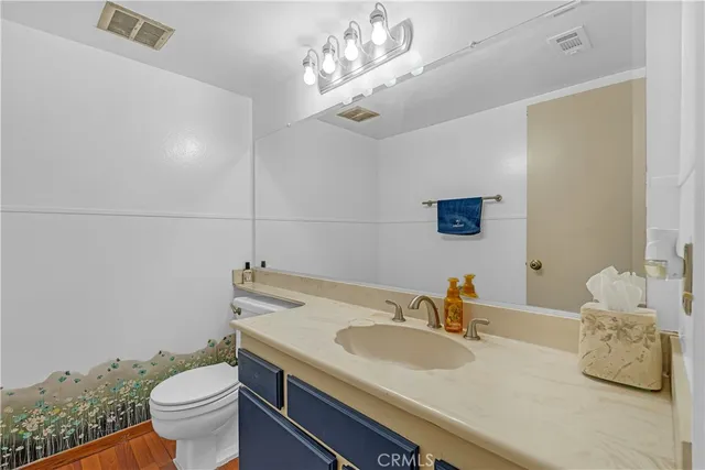 a bathroom with a granite countertop sink a toilet and a mirror