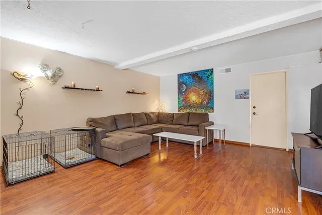 a living room with furniture a flat screen tv and a wooden floor