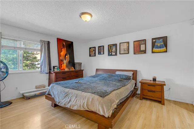 a bedroom with a bed and a dresser next to a window