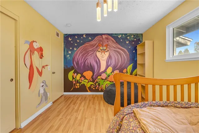 a bedroom with a bed and painting on the wall