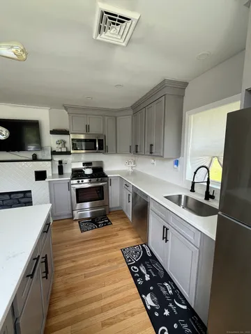 a kitchen with stainless steel appliances a stove sink microwave and cabinets