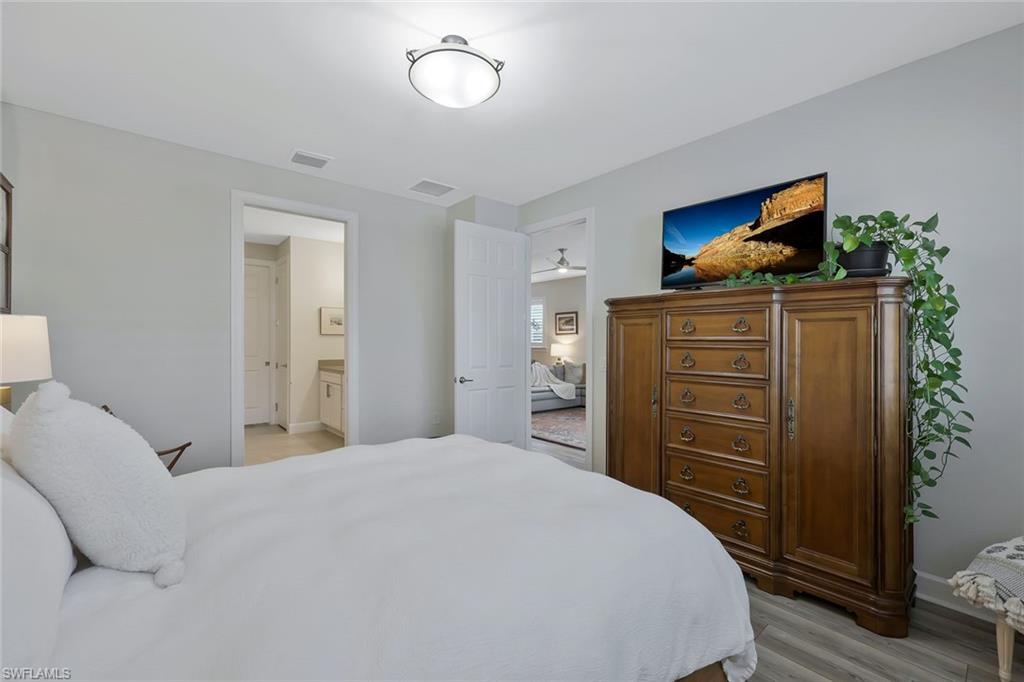 10787 Manatee Key Lane Estero, FL 33928 - Photo 12 of 31 a bedroom with a bed and cabinets