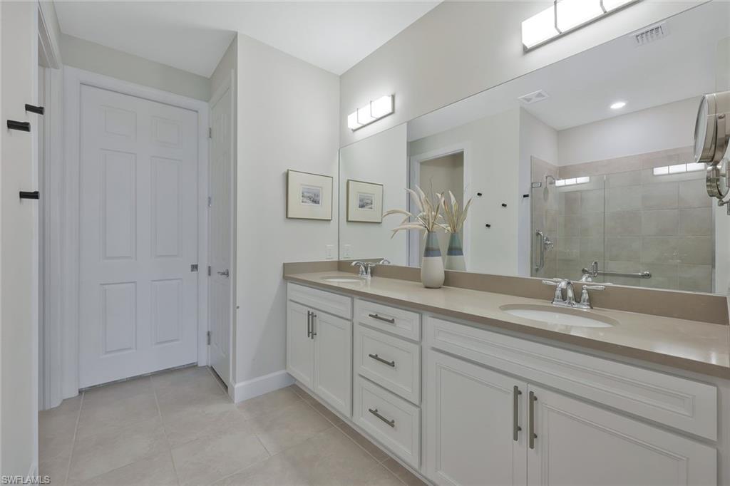 10787 Manatee Key Lane Estero, FL 33928 - Photo 13 of 31 a bathroom with double sink and a mirror