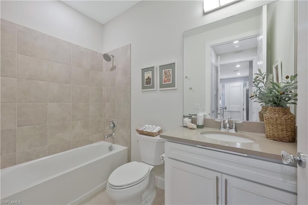 10787 Manatee Key Lane Estero, FL 33928 - Photo 15 of 31 a bathroom with a granite countertop sink a toilet tub and shower