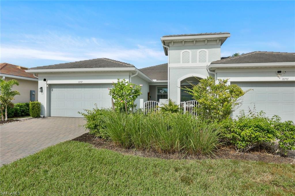 10787 Manatee Key Lane Estero, FL 33928 - Photo 21 of 31 a front view of a house with garden