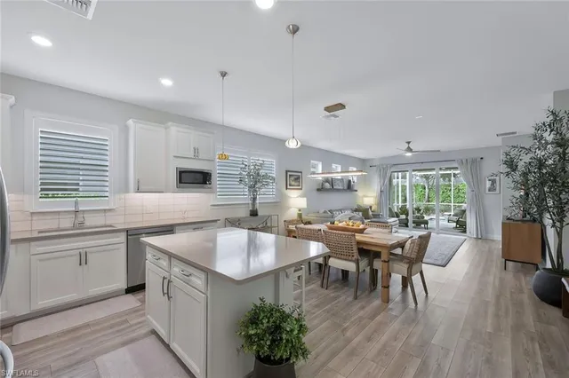 a large white kitchen with a large island in the center