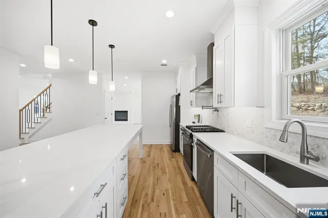 a kitchen with a sink a faucet a stove and a refrigerator