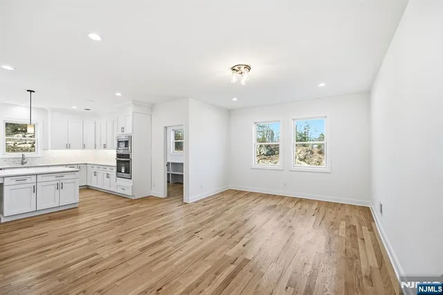 a view of a kitchen with wooden floor and a window