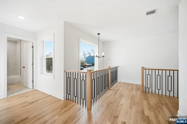 a view of a hallway with wooden floor and windows
