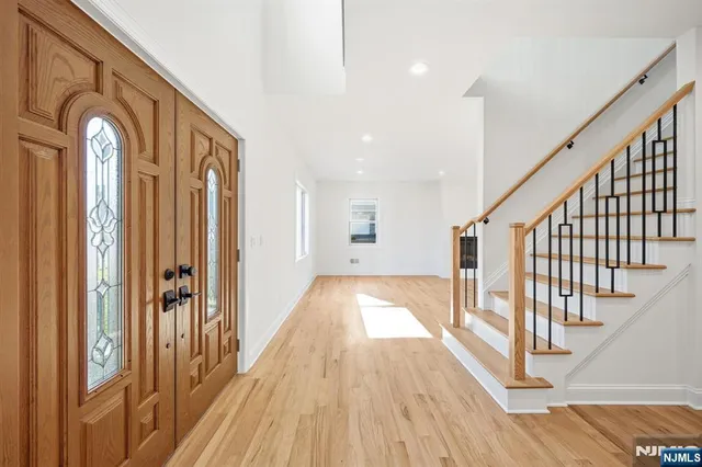 a view of a hallway with wooden floor and staircase