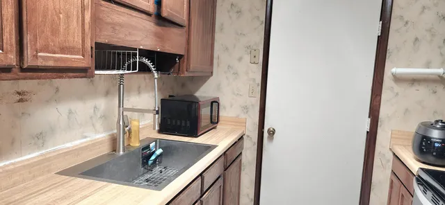 a kitchen with stainless steel appliances granite countertop a sink and a refrigerator