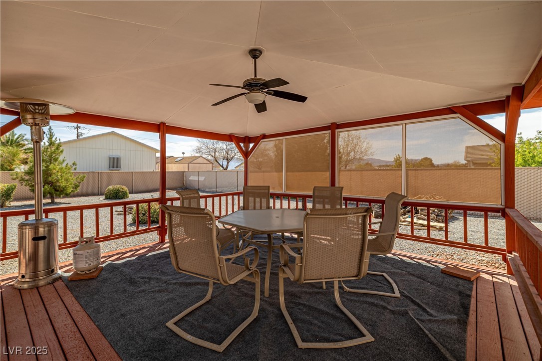 81 Diamond Bar Road Pahrump, NV 89048 - Photo 30 of 38 Wooden terrace featuring a fenced backyard, ceiling fan, and outdoor dining area