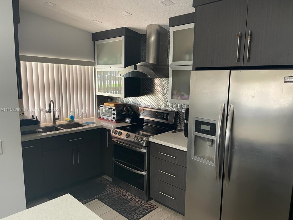 1115 North Park Road Hollywood, FL 33021 - Photo 4 of 6 a kitchen with stainless steel appliances granite countertop a stove a sink and a refrigerator