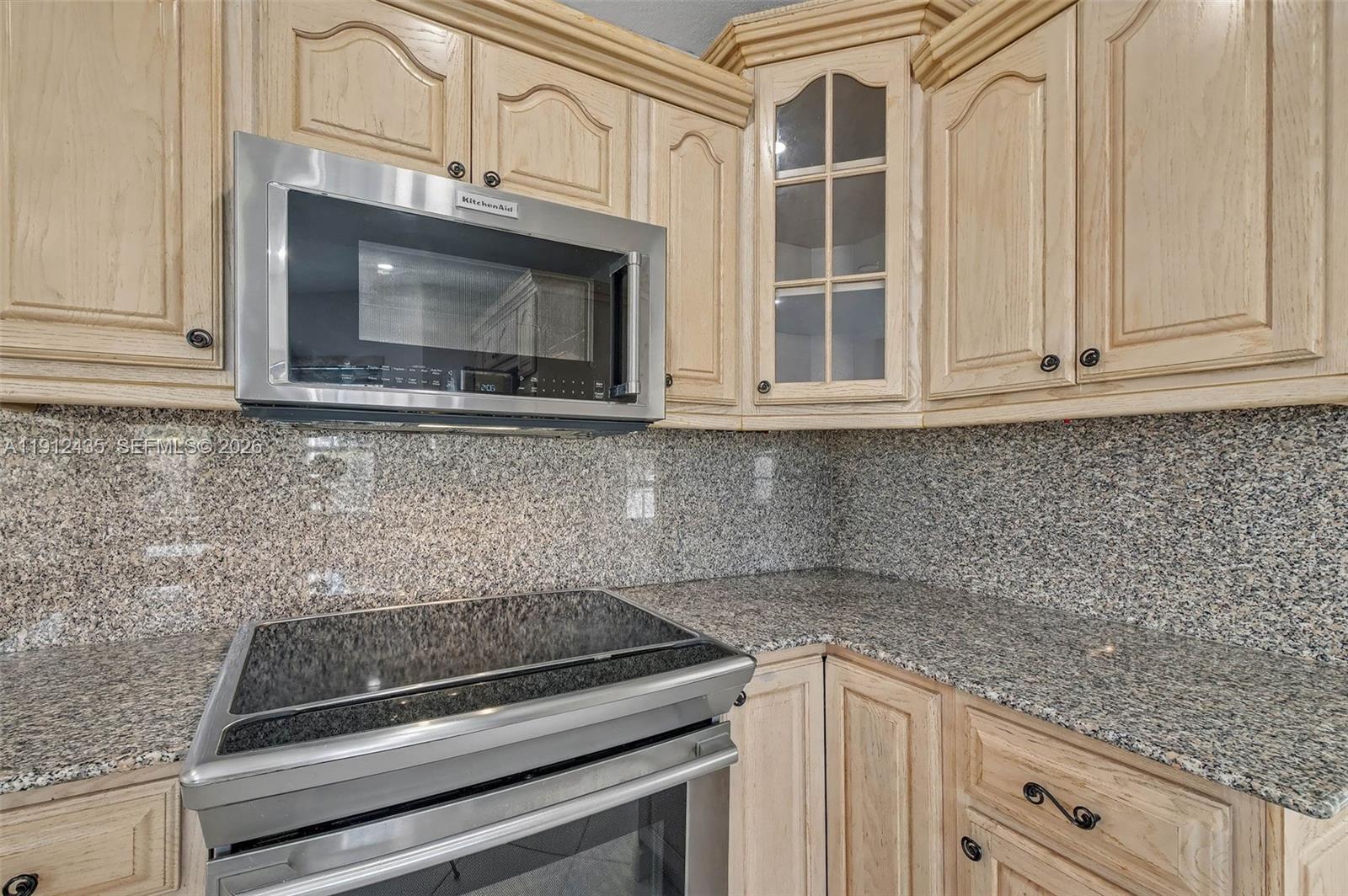 5936 Southwest 29th Street Miami, FL 33155 - Photo 11 of 32 a kitchen with granite countertop white cabinets stainless steel appliances and a counter space