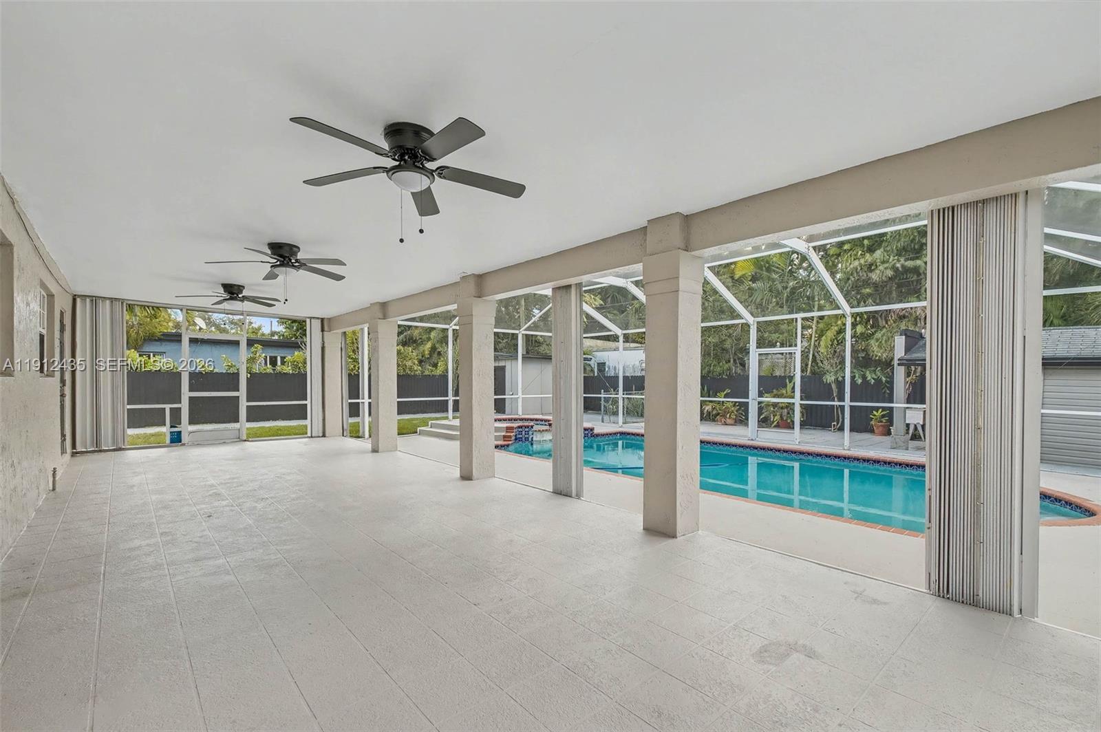 5936 Southwest 29th Street Miami, FL 33155 - Photo 13 of 32 a view of a livingroom with a ceiling fan and a large window