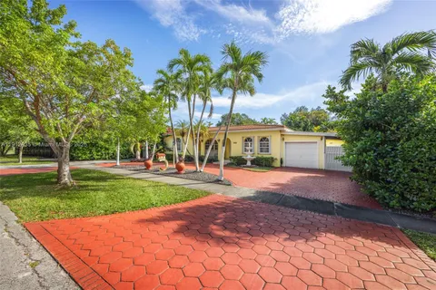 a front view of a house with a yard and a garden