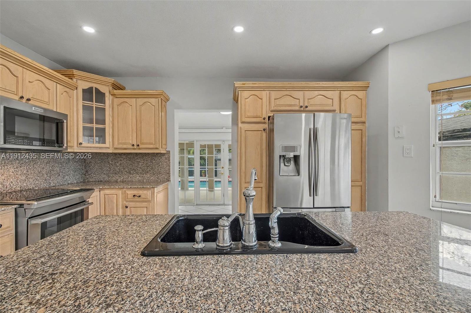 5936 Southwest 29th Street Miami, FL 33155 - Photo 9 of 32 a kitchen with granite countertop a sink and a refrigerator