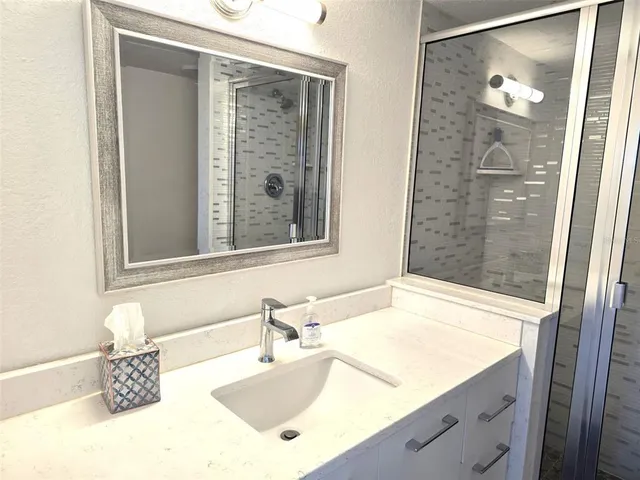 a bedroom with a bed and a lamp on dresser