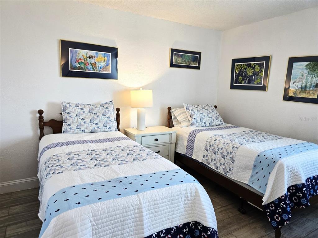 17408 Gulf Boulevard, Unit 1003 Redington Shores, FL 33708 - Photo 14 of 28 a bedroom with a bed and a lamp on dresser