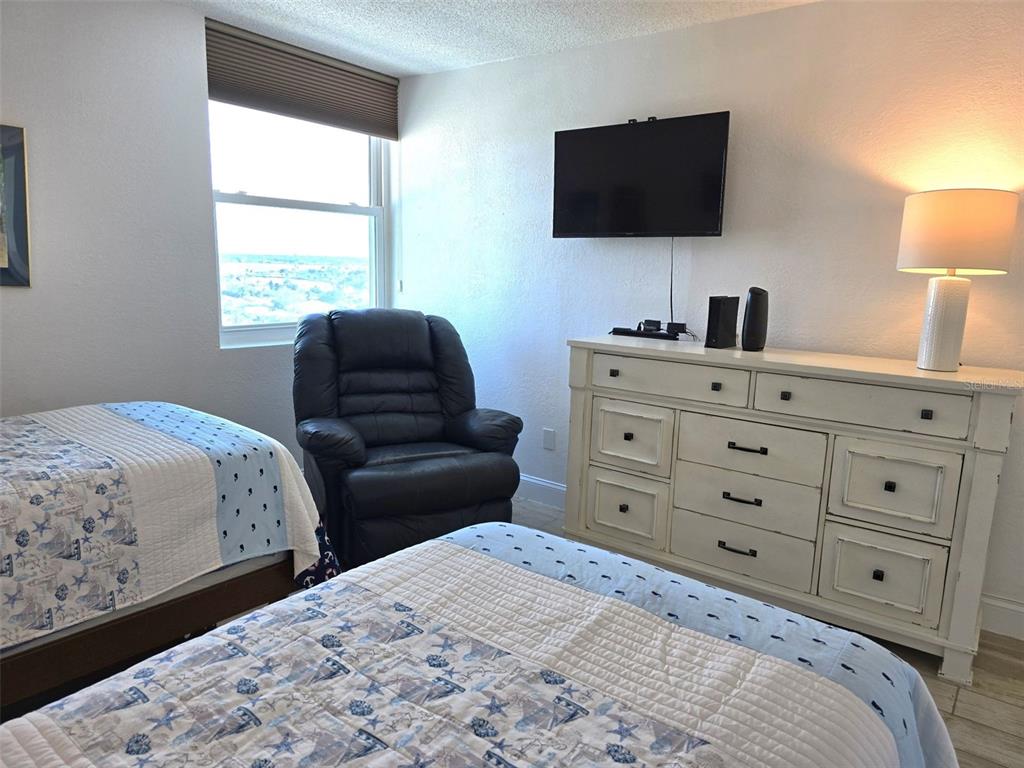 17408 Gulf Boulevard, Unit 1003 Redington Shores, FL 33708 - Photo 15 of 28 a bedroom with a bed and a flat screen tv
