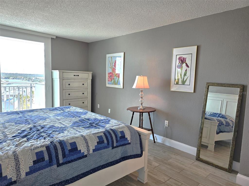 17408 Gulf Boulevard, Unit 1003 Redington Shores, FL 33708 - Photo 21 of 28 a bedroom with a bed and wooden floor