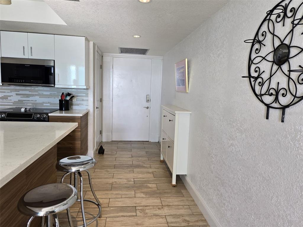 17408 Gulf Boulevard, Unit 1003 Redington Shores, FL 33708 - Photo 4 of 28 a kitchen with stainless steel appliances a refrigerator and a stove top oven