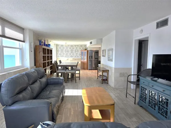a view of a dining room with furniture a rug and wooden floor