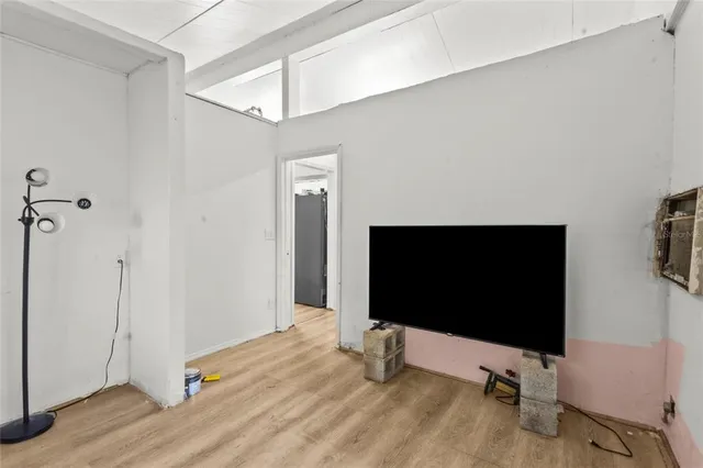 a living room with a flat screen tv and a hard wood floor