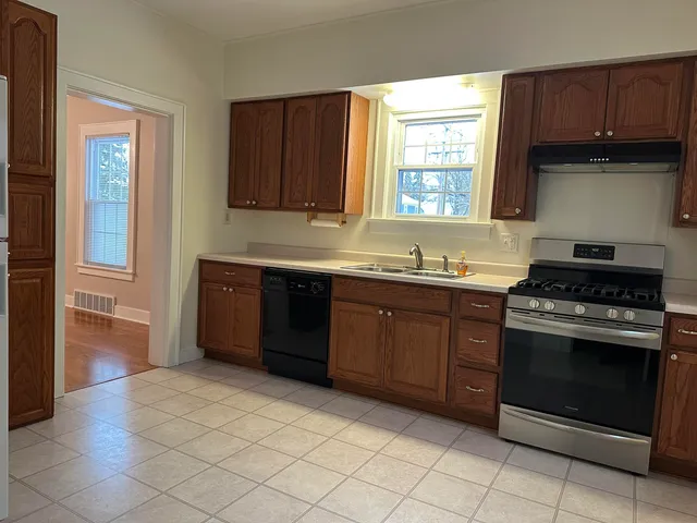 a kitchen with a stove sink and cabinets