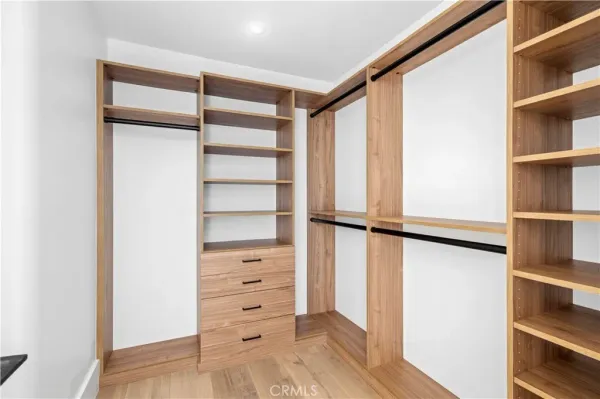 a view of walk in closet with empty racks