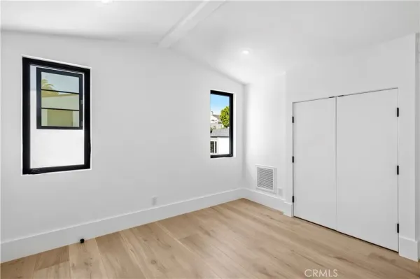 an empty room with a window and wooden floor