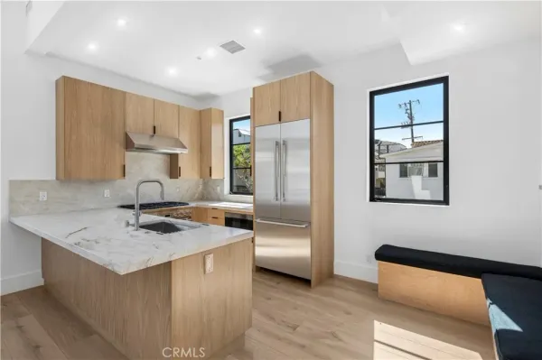 a kitchen with kitchen island a counter top space a sink stainless steel appliances and cabinets