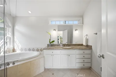 a bathroom with a granite countertop sink a large mirror and a vanity