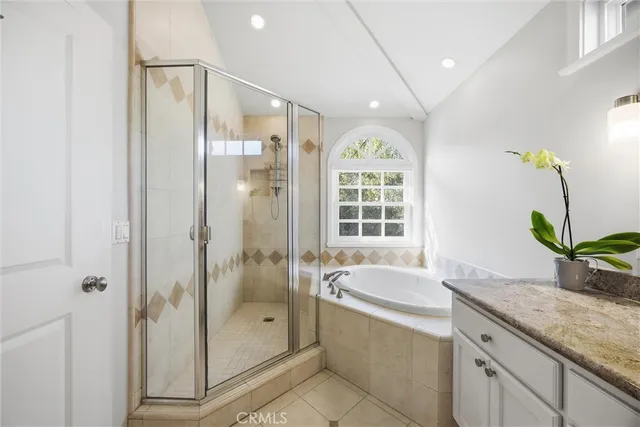 a bathroom with a granite countertop sink a mirror a bathtub and shower