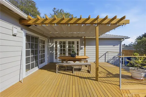 a view of a patio with table and chairs with wooden floor and fence
