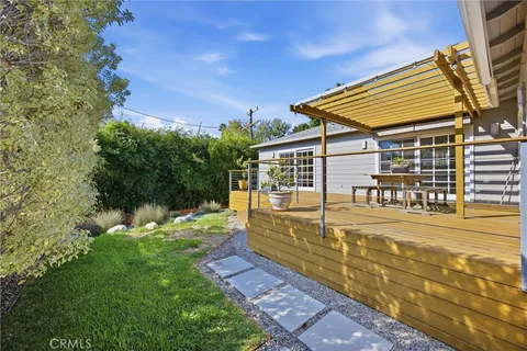 a view of a house with backyard and sitting area