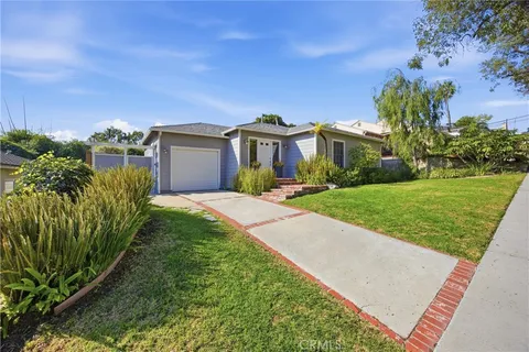 a front view of a house with a yard and potted plants