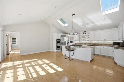 a kitchen with cabinets and wooden floor