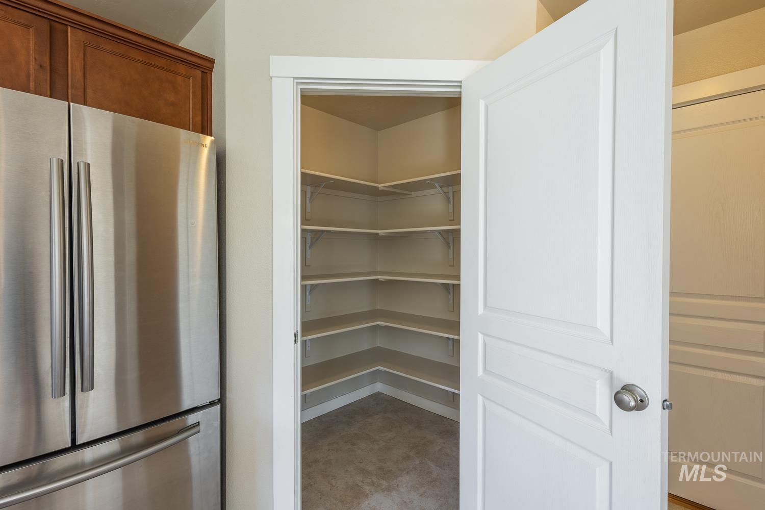 14253 Moreno Drive Caldwell, ID 83607 - Photo 14 of 48 Walk-in pantry with corner shelving, a white paneled door, and brushed nickel hardware