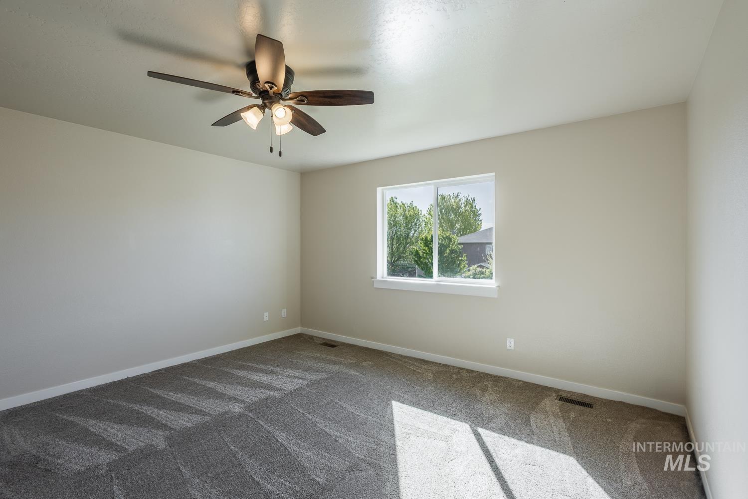 14253 Moreno Drive Caldwell, ID 83607 - Photo 17 of 48 Spacious room featuring neutral paint, textured carpet, and a ceiling fan with integrated lighting