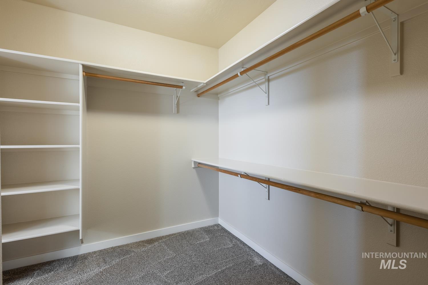 14253 Moreno Drive Caldwell, ID 83607 - Photo 24 of 48 Spacious walk-in closet featuring white built-in shelving, multiple hanging rods, and ample storage space