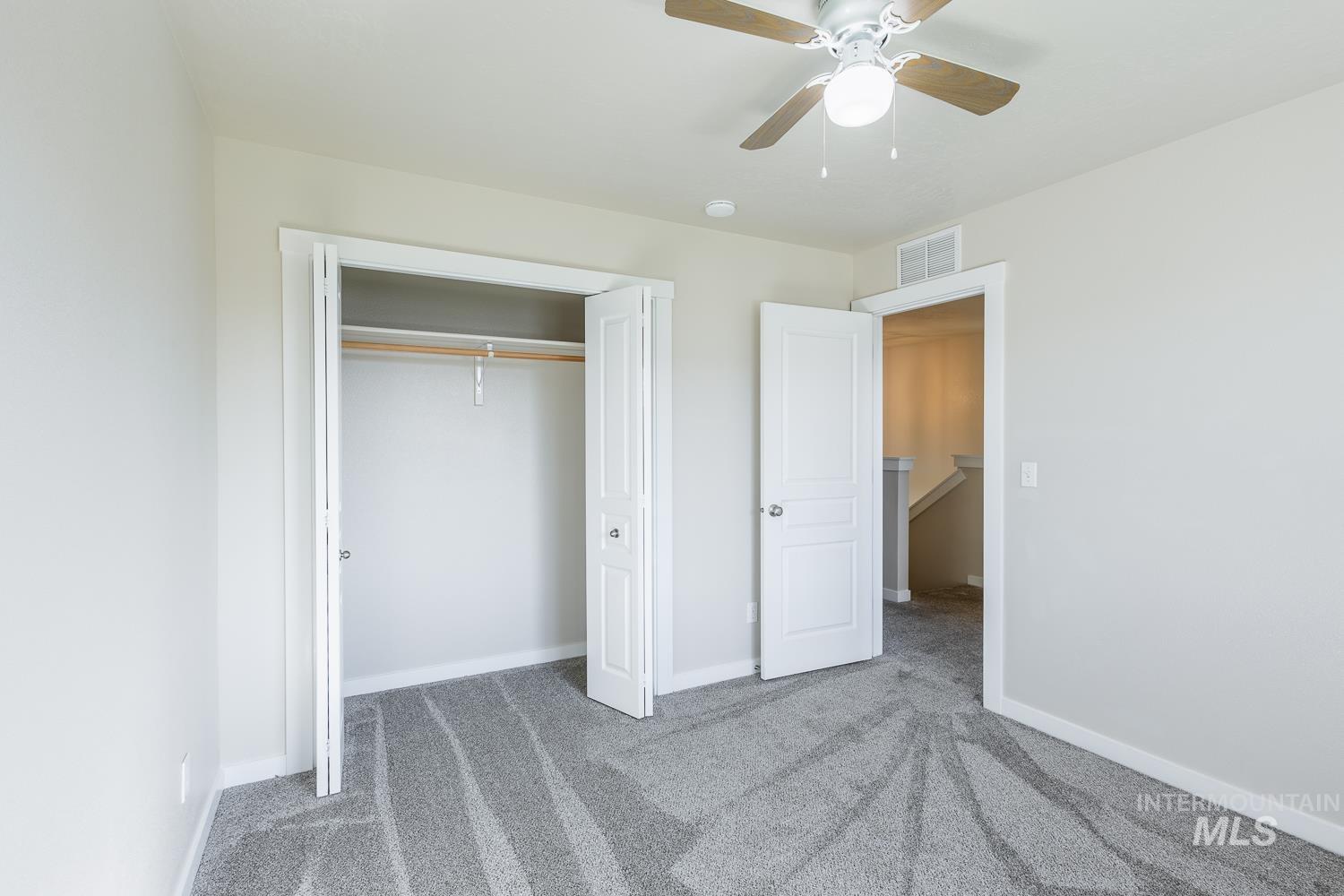 14253 Moreno Drive Caldwell, ID 83607 - Photo 26 of 48 Carpeted interior room featuring a bi-fold door closet with an interior rod, a white ceiling fan with integrated lighting, and a white interior door