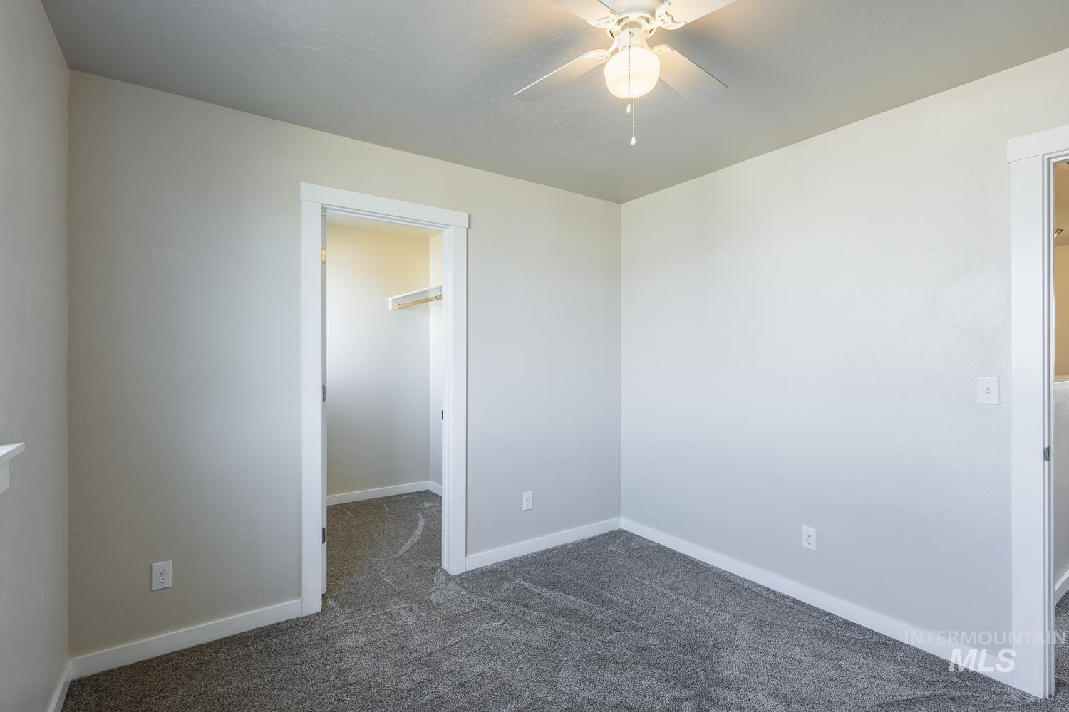 14253 Moreno Drive Caldwell, ID 83607 - Photo 33 of 48 Spacious room featuring neutral-toned walls, plush grey carpeting, and a ceiling fan with integrated lighting