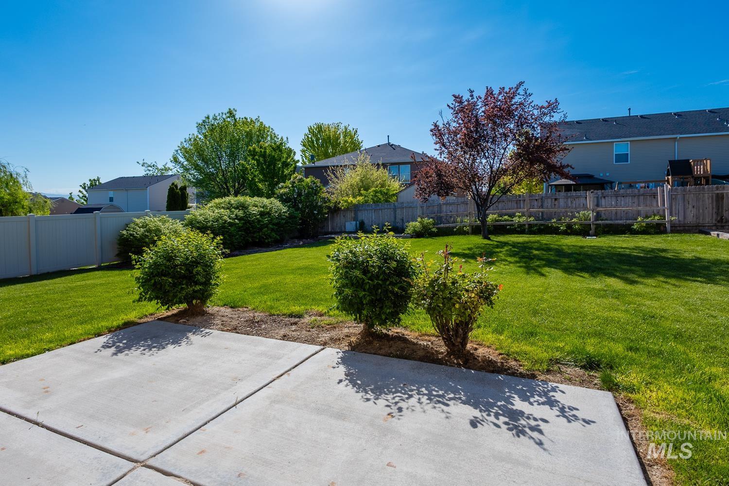 14253 Moreno Drive Caldwell, ID 83607 - Photo 34 of 48 Spacious backyard featuring a concrete patio, expansive lawn, established trees, and mature landscaping