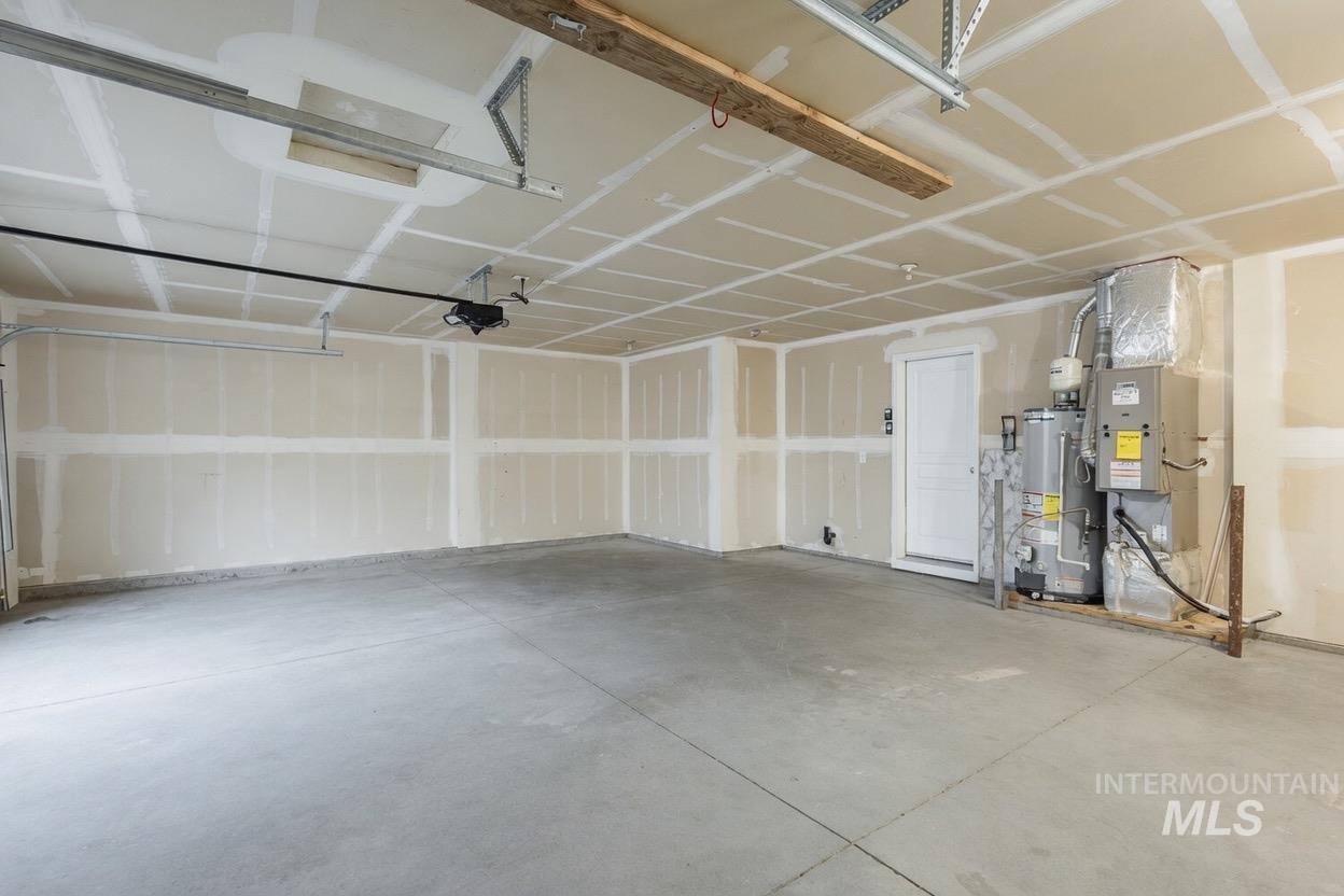 14253 Moreno Drive Caldwell, ID 83607 - Photo 41 of 48 Spacious two-car garage featuring a concrete floor, an overhead garage door opener, an interior access door, a water heater, and an HVAC unit