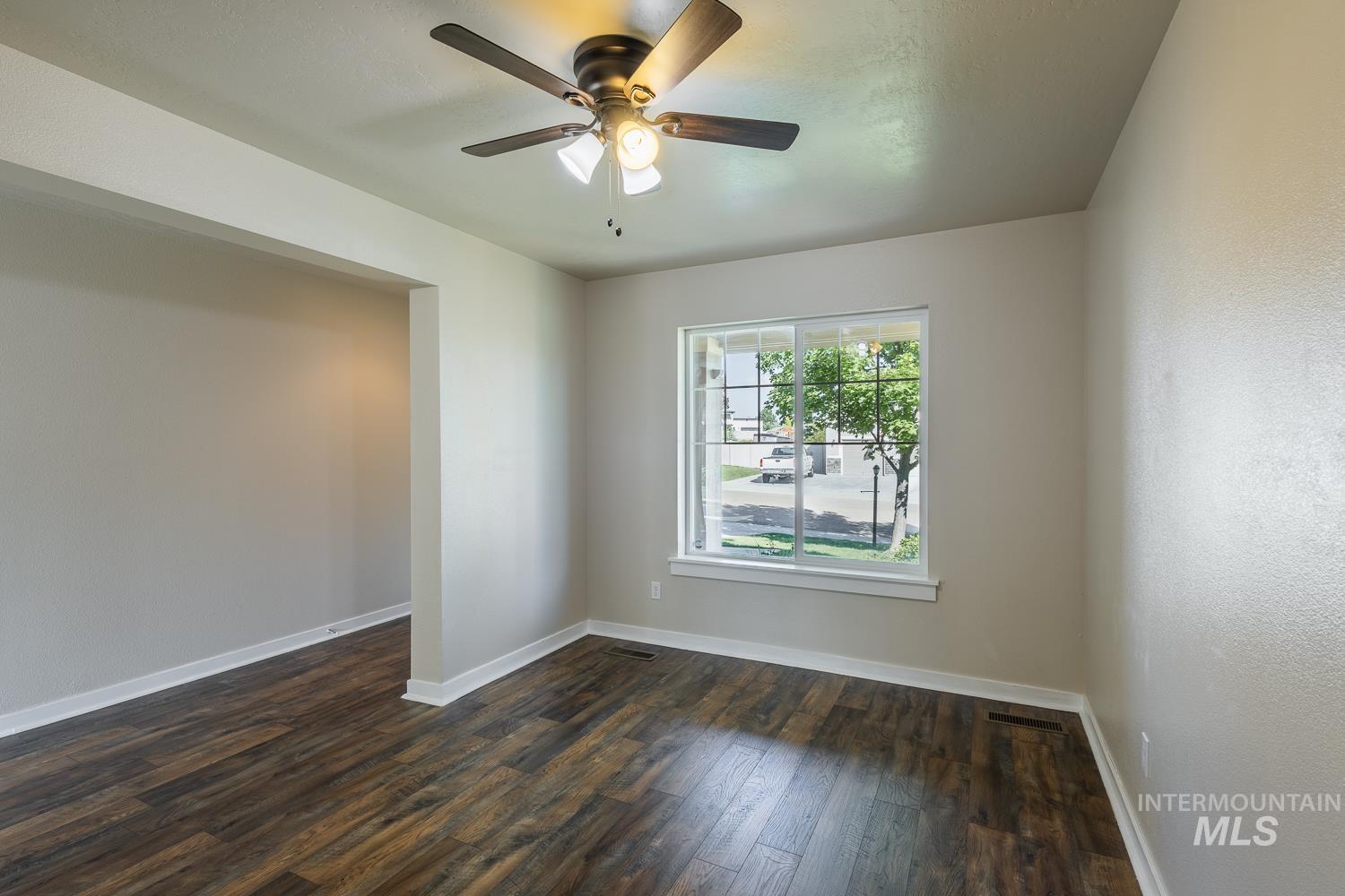 14253 Moreno Drive Caldwell, ID 83607 - Photo 6 of 48 Spacious room featuring wood-finish flooring, a contemporary ceiling fan with integrated lighting, and a large window with white trim