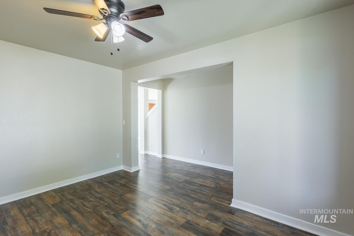 14253 Moreno Drive Caldwell, ID 83607 - Photo 7 of 48 Spacious interior room featuring wood-finish flooring, light-colored walls, and a ceiling fan with integrated lighting