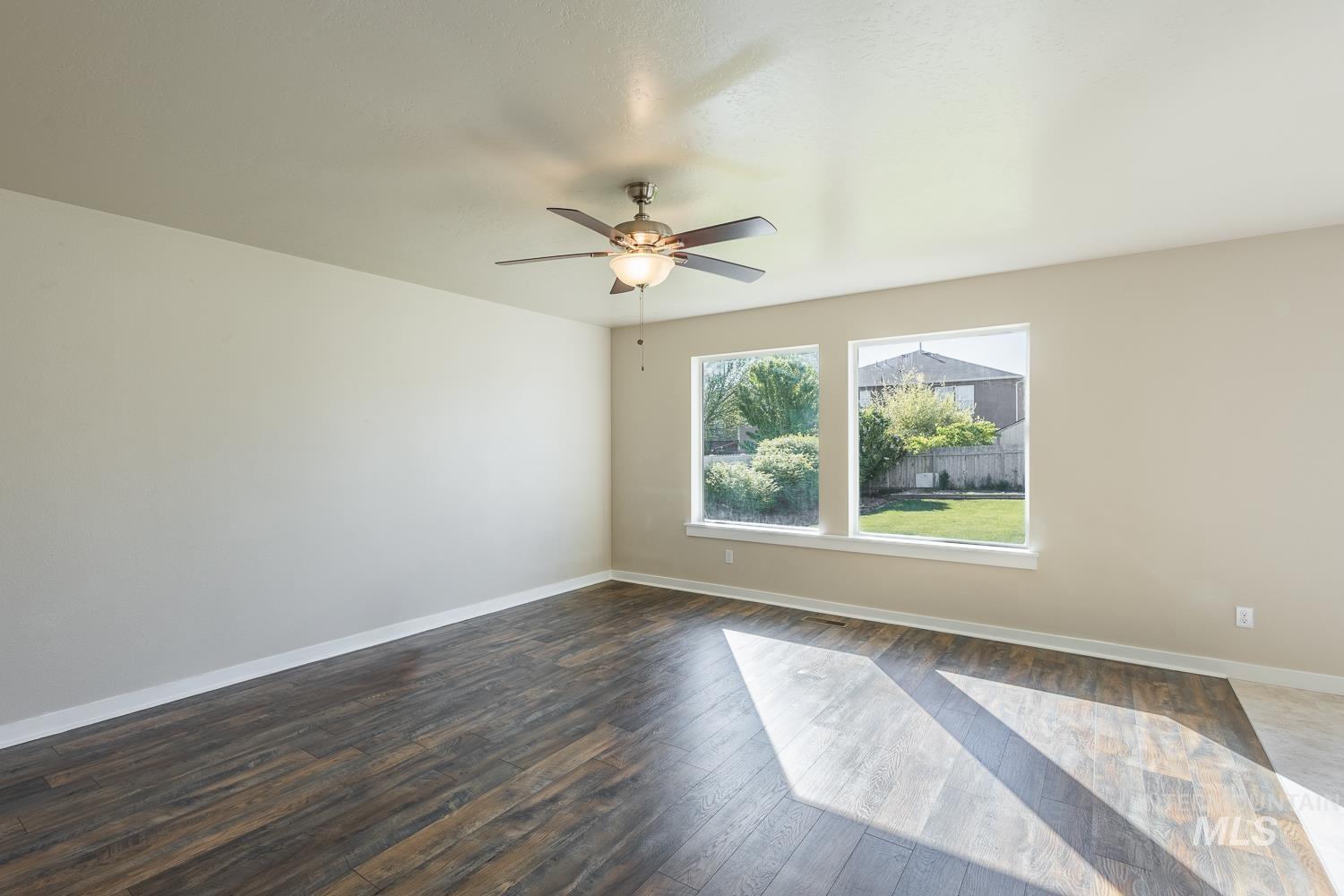 14253 Moreno Drive Caldwell, ID 83607 - Photo 9 of 48 Spacious room featuring wood-finish flooring, light neutral wall tones, and two large windows with backyard views